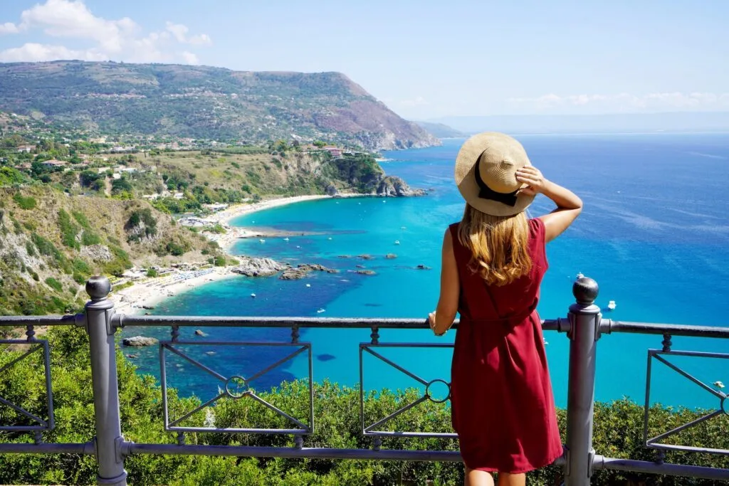 Traveling in Italy. Panoramic view of elegant woman with hat in Capo Vaticano in the Coast of the Gods, Calabria, Italy.